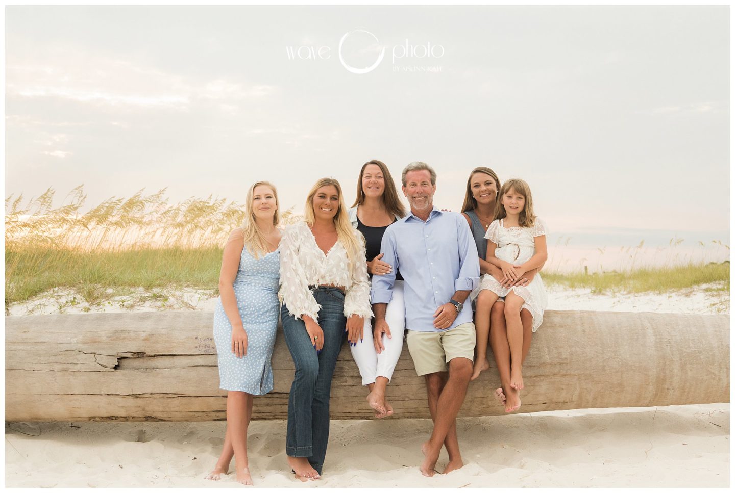 family-sitting-on-log-smiling-orange-beach-gulf-shores-beach-florida